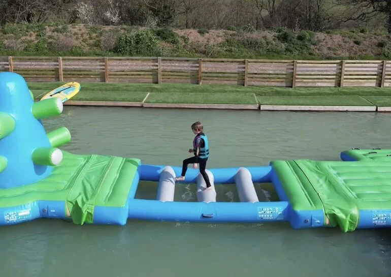 Child crossing an aqua park obstacle.