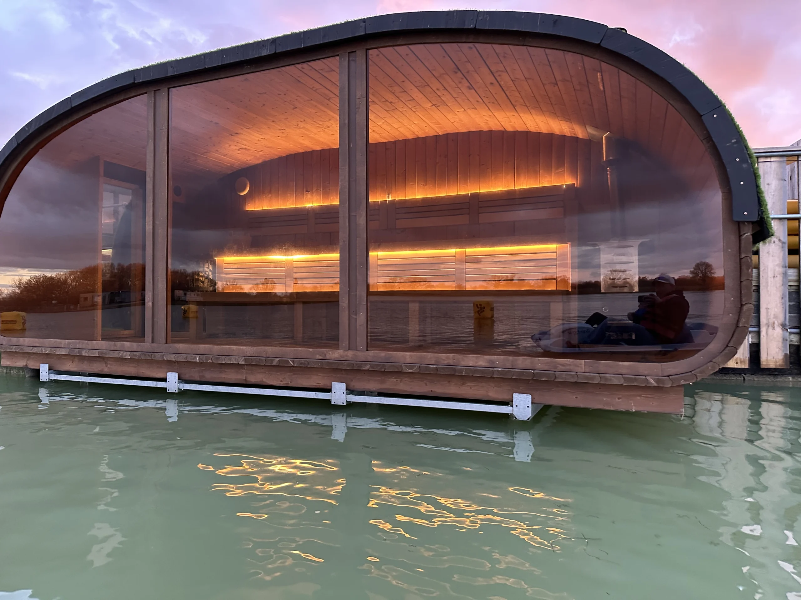 Floating sauna cabin moored on the lake at West Country Water Park, Bristol, surrounded by open countryside