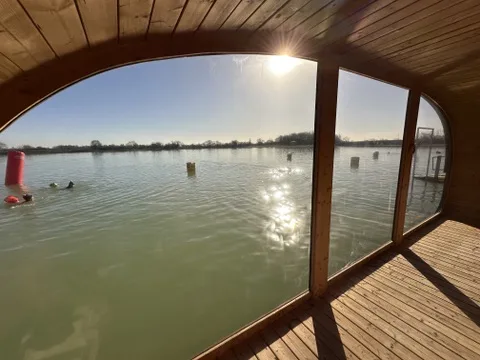Guests relaxing inside the floating sauna at West Country Water Park, Bristol, between heat and cold lake plunge rounds