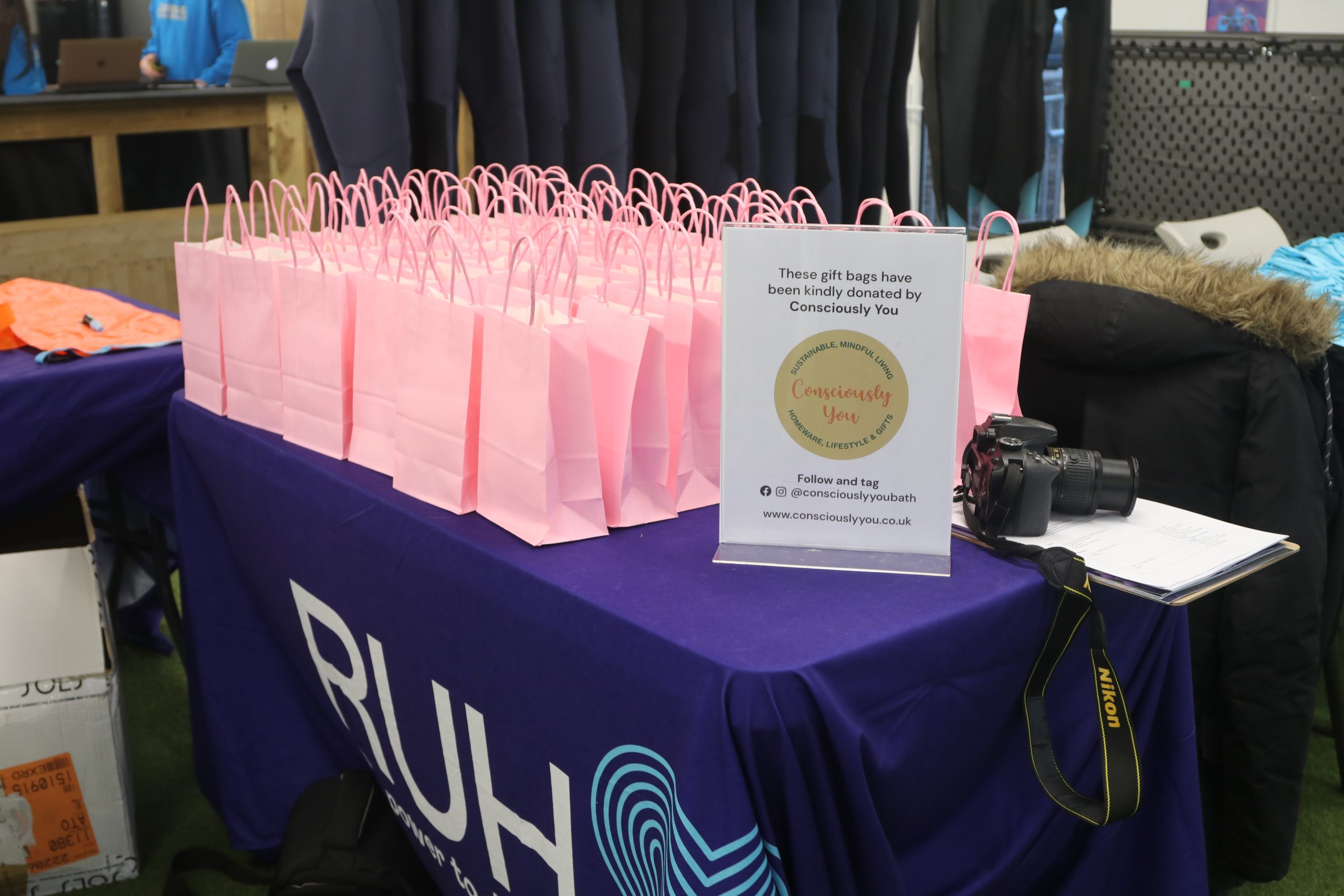 collection of gift bags displayed on a charity branded table.