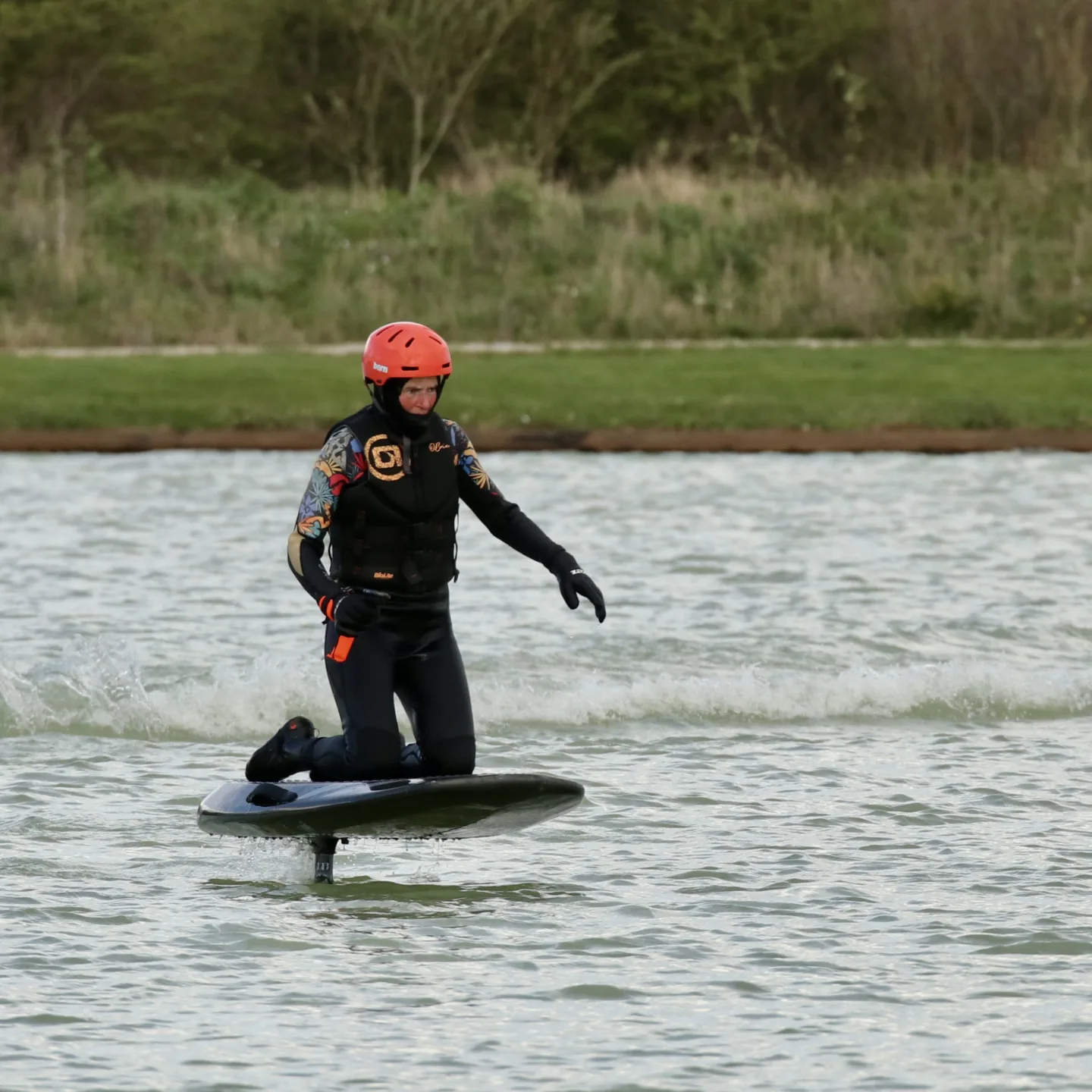 Instructor guiding a beginner through their first e-foil boarding session on the lake at West Country Water Park
