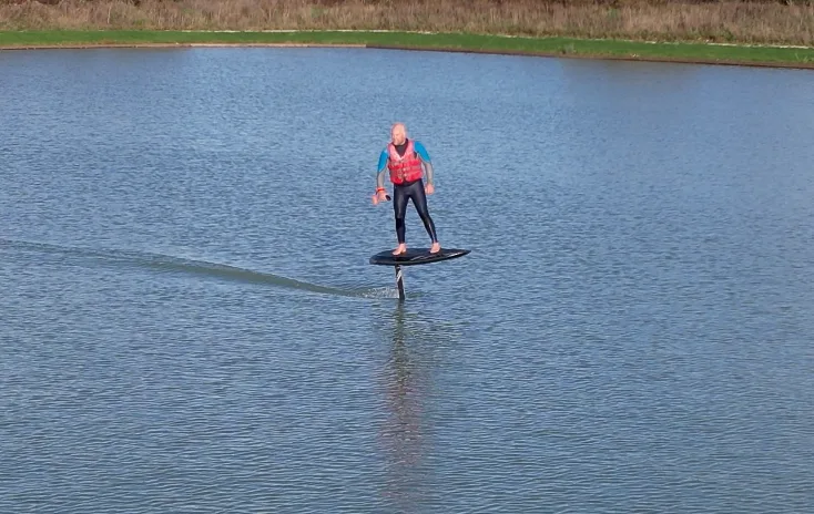 Group e-foil boarding session on the calm lake at West Country Water Park showing progression and group lessons